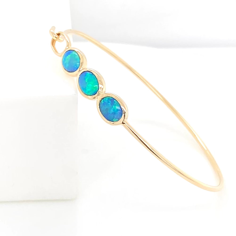 Armring i 14 karat guld med 3 stk. 7 x 5 mm solid krystal opaler fra Australien.