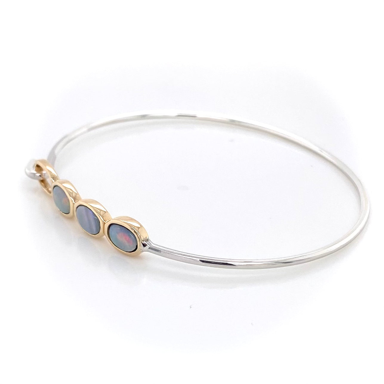 Armring i 14 karat guld og sterling sølv med 3 stk. 6 x 4 mm solid krystal opaler fra Australien.
