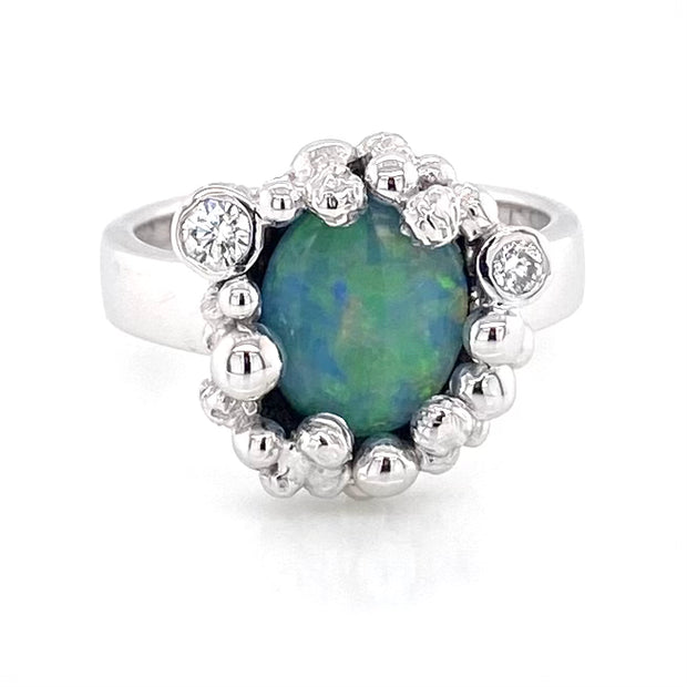 Ægte australsk Opal ring i sølv med solid crystal opal
Opalen er oval og er indfattet med kugler hele vejen omkring opalen som er grøn