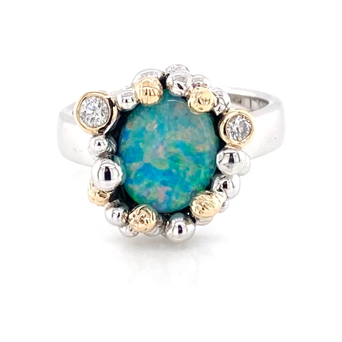 Ægte australsk Opal ring i sølv og guld, med solid crystal opal
Opalen er oval og er indfattet med kugler hele vejen omkring opalen som er blågrøn