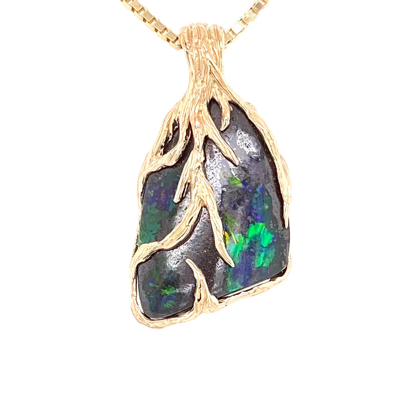 Australsk Boulder opal indfattet i 14K guld. 
Rustik design af grene der omfavner opalen