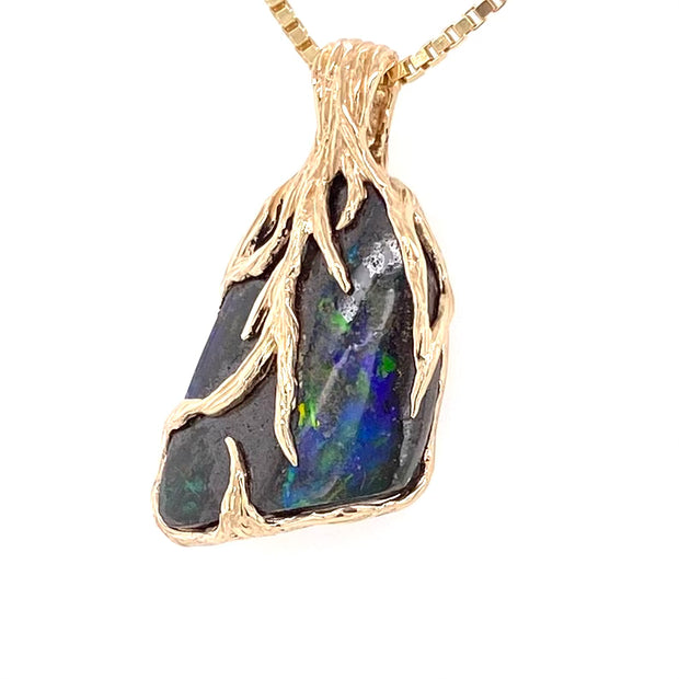 Ægte Australsk Boulder opal indfattet i 14K guld. Rustik design af grene der omfavner opalen.
