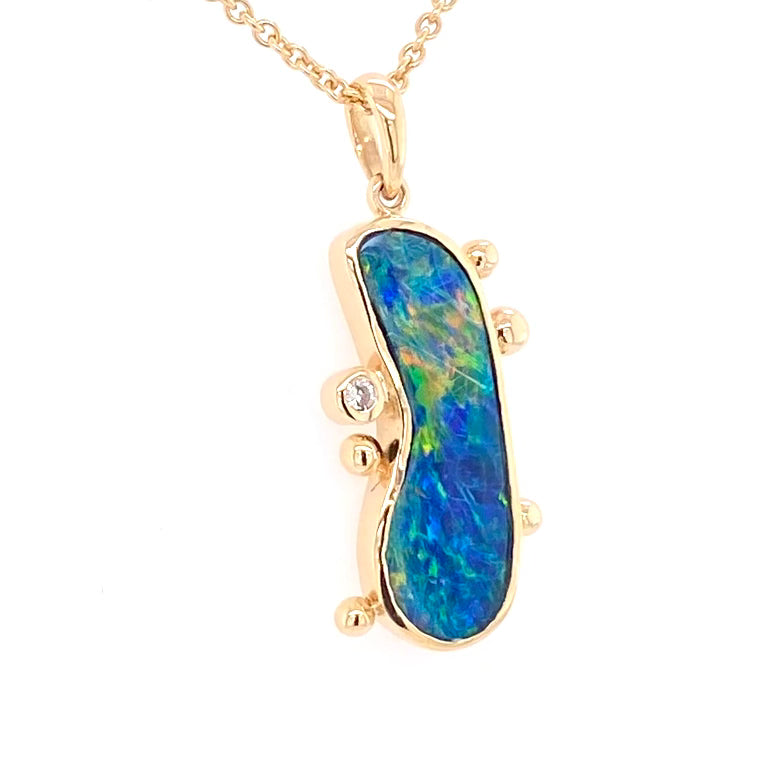 Ægte doublet opal fra Australien indfattet i 14 karat guld og med 0,03 carat diamant og guld klumper på siden.