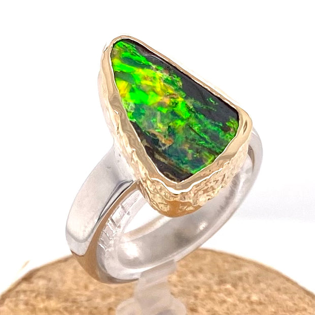 Ring med ægte solid boulder opal fra Australien indfattet i 14 karat rustikt guld og ringskinnen er lavet af blankt sterling sølv.