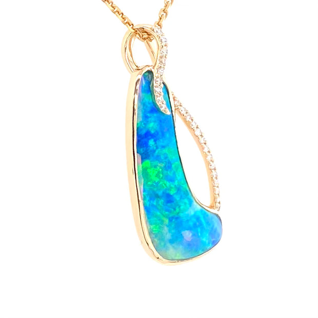 Opal vedhænget har en ægte solid Australsk krystal opal som er indfattet i 14 karat guld. Opalen er 3,42 ct, og har 23 brilliant diamant 0,15 ct. W/SI.