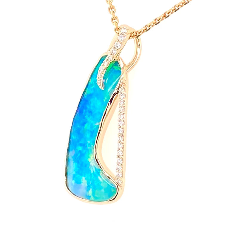 Opal vedhænget har en ægte solid Australsk krystal opal som er indfattet i 14 karat guld. Opalen er 3,42 ct, og har 23 brilliant diamant 0,15 ct. W/SI.