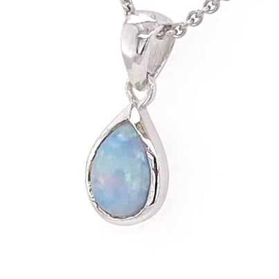 Vedhæng med en ægte solid krystal opal fra Australien indfattet i blankt rhodineret sterling sølv.