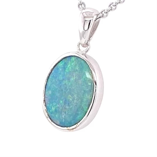 Vedhæng med en ægte solid krystal opal fra Australien indfattet i blankt rhodineret sterling sølv.