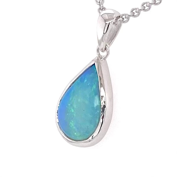 Vedhæng med en ægte solid krystal opal fra Australien indfattet i blankt rhodineret sterling sølv.