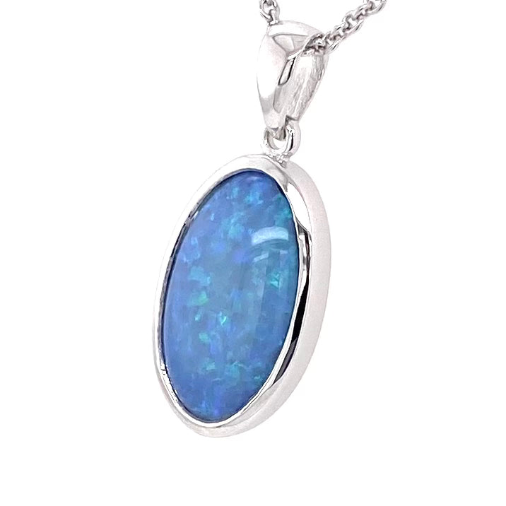 Vedhæng med en ægte solid krystal opal fra Australien indfattet i blankt rhodineret sterling sølv.
