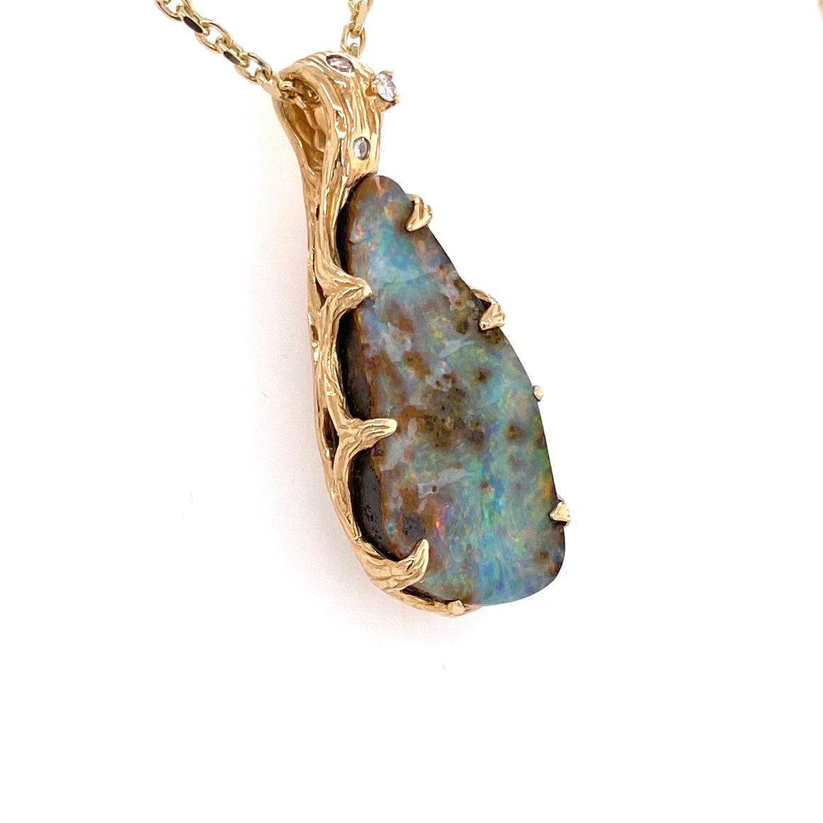 Ægte solid boulder opal fra Australien indfattet i 14 karat rustikt guld. De krogede rustikke grene af 14 karat guld holder opalen på plads. 0,05 ct diamanter.