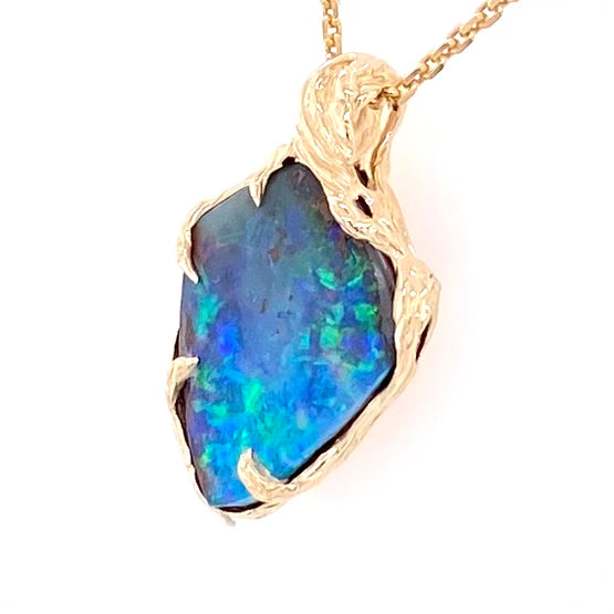 Vedhæng med en ægte solid boulder opal fra Australien indfattet i 14 karat rustikt guld. De krogede rustikke grene af 14 karat guld holder opalen på plads.