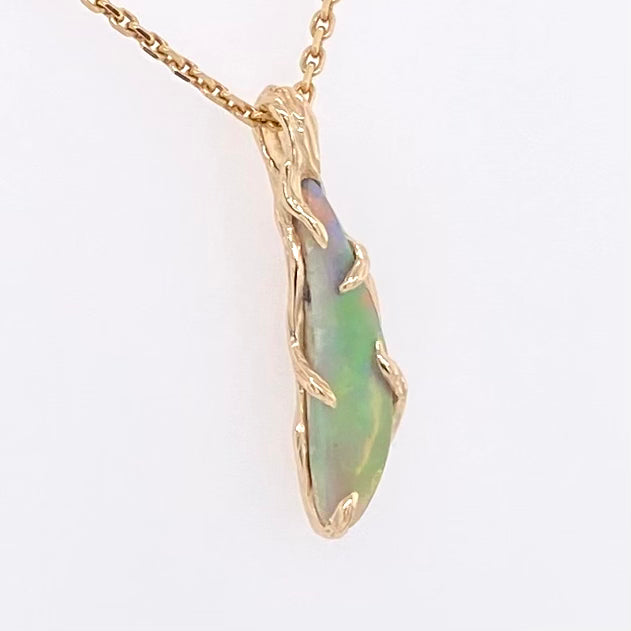 Vedhæng med en ægte solid crystal opal fra vores egen mine i Lightning Ridge, Australien. Indfattet i 14 karat rustikt guld. De krogede rustikke grene af 14 karat guld holder opalen på plads. Opalen vejer 1,12 ct.