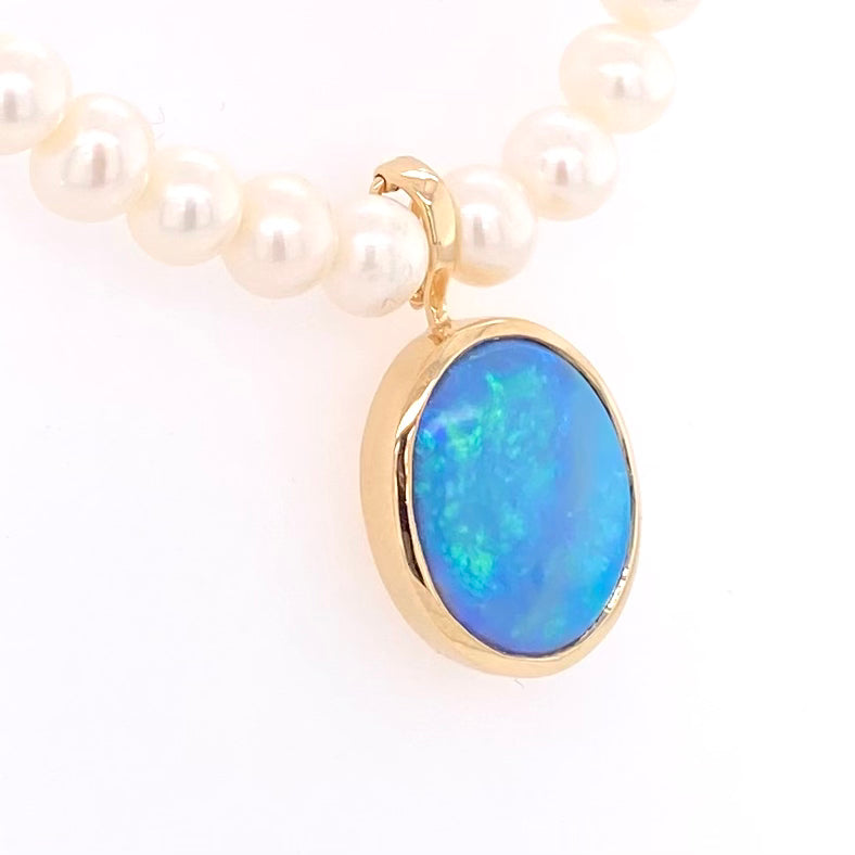 Vedhæng med en ægte solid crystal opal fra Australien, indfattet i 14 karat guld. Vedhænget er lavet som en clips, da den er beregnet til at clipse på en perlekæde. Vedhænget vejer 7,64 ct.