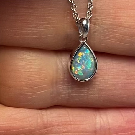 Vedhæng med en ægte solid krystal opal fra Australien indfattet i rhodineret sterling sølv.
