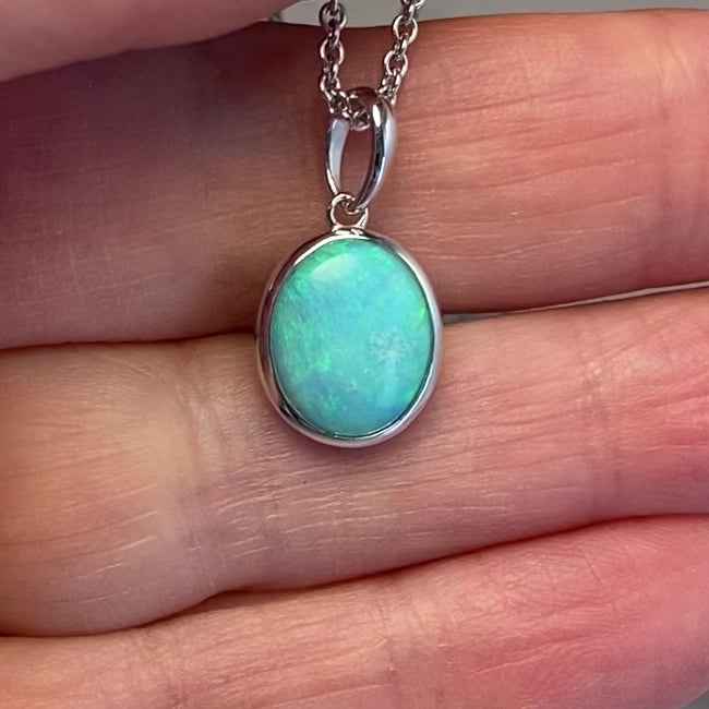 Vedhæng med en ægte solid krystal opal fra Australien indfattet i rhodineret sterling sølv.