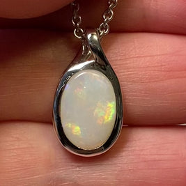 Vedhæng med en ægte solid krystal opal fra Australien indfattet i rhodineret sterling sølv.