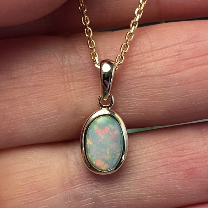 Vedhæng med en ægte solid krystal opal fra Australien indfattet i 14 karat guld.