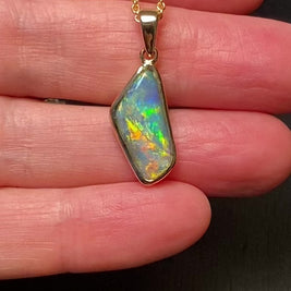 Guld vedhæng med en ægte solid sort opal fra vores mine i Lightning Ridge, Australien indfattet i 14 karat blankt guld.