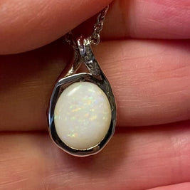 Vedhæng med en ægte solid krystal opal fra Australien indfattet i rhodineret sterling sølv.