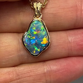 Vedhæng med en ægte solid krystal opal fra Australien indfattet i 14 karat guld.