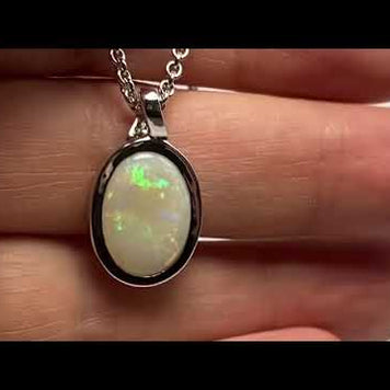 Vedhæng med en ægte solid krystal opal fra Australien indfattet i blankt rhodineret sterling sølv.