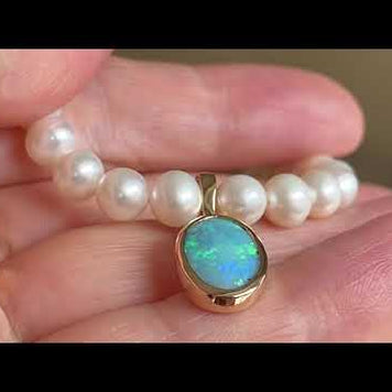 Vedhæng med en ægte solid crystal opal fra Australien, indfattet i 14 karat guld. Vedhænget er lavet som en clips, da den er beregnet til at clipse på en perlekæde. Opalen vejer 1,57 ct.
