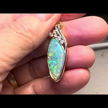 Opal vedhænget har en ægte solid Australsk krystal opal som er indfattet i 14 karat guld. Opalen er 3,71 ct. Vedhænget har 5 diamanter: 0,20 ct. i alt, 2x 0,05 ct, 2x 0,03 ct. og 1x 0,02 ct. W/SI.
