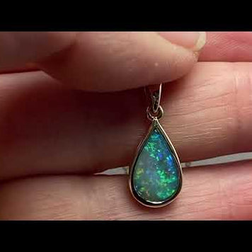 Vedhæng med en ægte solid krystal opal fra Australien indfattet i 14 karat guld.