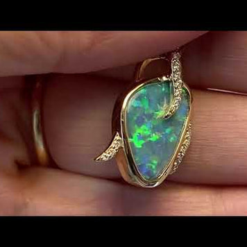 Opal vedhænget har en ægte solid Australsk krystal opal som er indfattet i 14 karat guld. Opalen er 2,49 ct, og har 19 brillanter 0,09 ct. W/SI i alt.