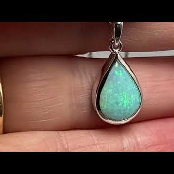 Vedhæng med en ægte solid krystal opal fra Australien indfattet i blankt rhodineret sterling sølv.