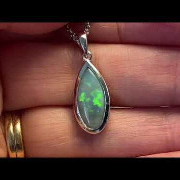 Vedhæng med en ægte solid krystal opal fra Australien indfattet i rhodineret sterling sølv.