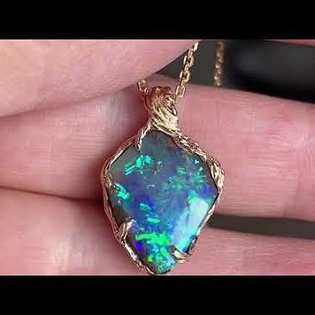 Vedhæng med en ægte solid boulder opal fra Australien indfattet i 14 karat rustikt guld. De krogede rustikke grene af 14 karat guld holder opalen på plads.