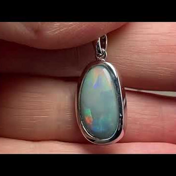 Vedhæng med en ægte solid krystal opal fra Australien indfattet i blankt rhodineret sterling sølv.