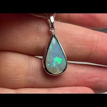 Vedhæng med en ægte solid krystal opal fra Australien indfattet i blankt rhodineret sterling sølv.