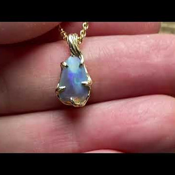 Ægte solid krystal opal fra vores egen mine i Lightning Ridge, Australien indfattet i 14 karat guld. De krogede grene af 14 karat guld holder opalen på plads.