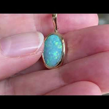 Vedhæng med en ægte solid crystal opal fra Australien, indfattet i 14 karat guld. Vedhænget er lavet som en clips, da den er beregnet til at clipse på en perlekæde. Vedhænget vejer 7,64 ct.