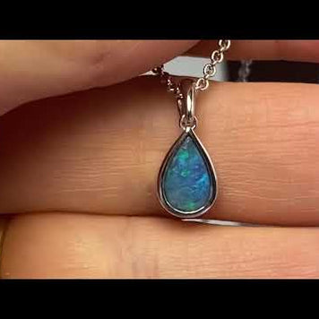 Vedhæng med en ægte solid krystal opal fra Australien indfattet i rhodineret sterling sølv.