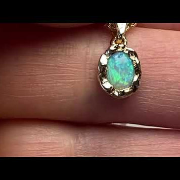 Vedhæng med en ægte solid krystal opal fra Australien indfattet i et rustikt vedhæng med organiske former i 14 karat guld.