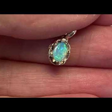 Vedhæng med en ægte solid krystal opal fra Australien indfattet i et rustikt vedhæng med organiske former i 14 karat guld.