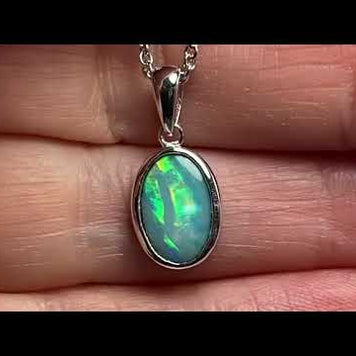 Vedhæng med en ægte solid krystal opal fra Australien indfattet i rhodineret sterling sølv.