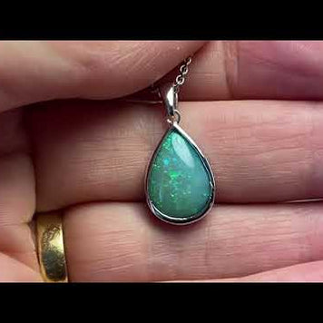 Vedhæng med en ægte solid krystal opal fra Australien indfattet i blankt rhodineret sterling sølv.