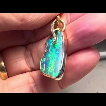 Opal vedhænget har en ægte solid Australsk krystal opal som er indfattet i 14 karat guld. Opalen er 5,38 ct. Med 10 brilliant diamanter 0,07 ct. W/SI.