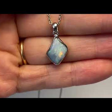 Vedhæng med en ægte solid krystal opal fra Australien indfattet i blankt rhodineret sterling sølv.