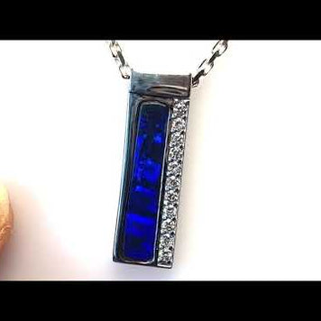 Vedhæng med en ægte solid crystal opal fra vores egen mine i Lightning Ridge, Australien. Indfattet i blankt sterling sølv. Opalen vejer 4,5 ct., og der er isat 0,55 ct. lab diamanter.