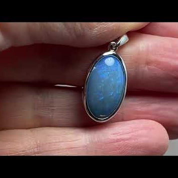 Vedhæng med en ægte solid krystal opal fra Australien indfattet i blankt rhodineret sterling sølv.