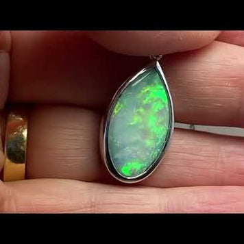 Vedhæng med en ægte solid krystal opal fra Australien indfattet i blankt rhodineret sterling sølv.