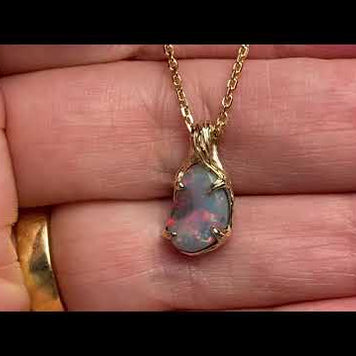 Vedhæng med en ægte solid crystal opal fra vores egen mine i Lightning Ridge, Australien. Indfattet i 14 karat rustikt guld. De krogede rustikke grene af 14 karat guld holder opalen på plads. Opalen vejer 1,36 ct., og har N6 bodytone.