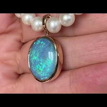 Vedhæng med en ægte solid crystal opal fra Australien, indfattet i 14 karat guld. Vedhænget er lavet som en clips, da den er beregnet til at clipse på en perlekæde. Vedhænget vejer 7,64 ct.