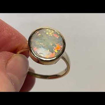 Ring med en ægte solid krystal opal fra Australien indfattet i 14 karat guld.